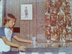 boy playing pinball game 1970s